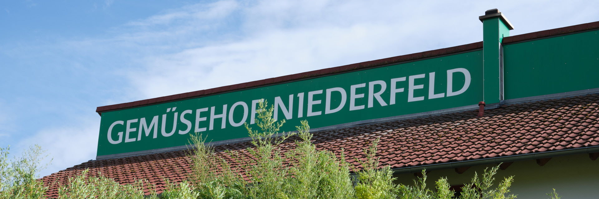 Ein grünes Schild mit der Aufschrift "Gemüsehof Niederfeld"