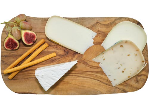 Verschiedene Käsesorten aus Schafs- und Ziegenmilch, angerichtet auf einer Olivenholzplatte