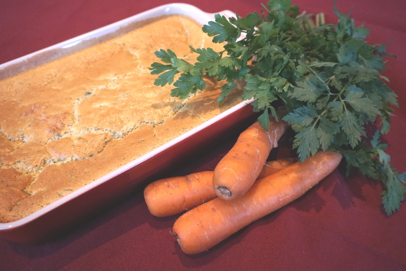 Leckerer Karottenauflauf angerichtet mit frischen Karotten